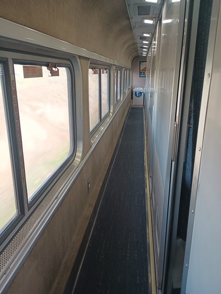 train room with a bath, and roomette, looking at the track behind the last car, looking down the very narrow hallway