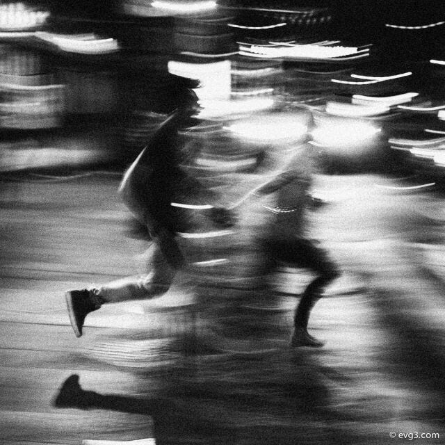 This may contain: blurry photograph of people running in the street