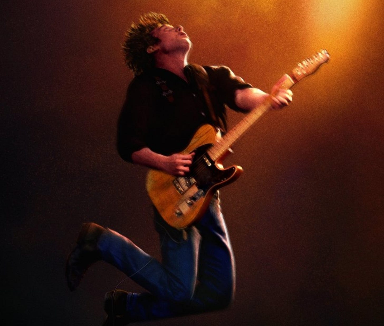Picture of Jeremy Allen White as Bruce jumping in the air with his guitar.