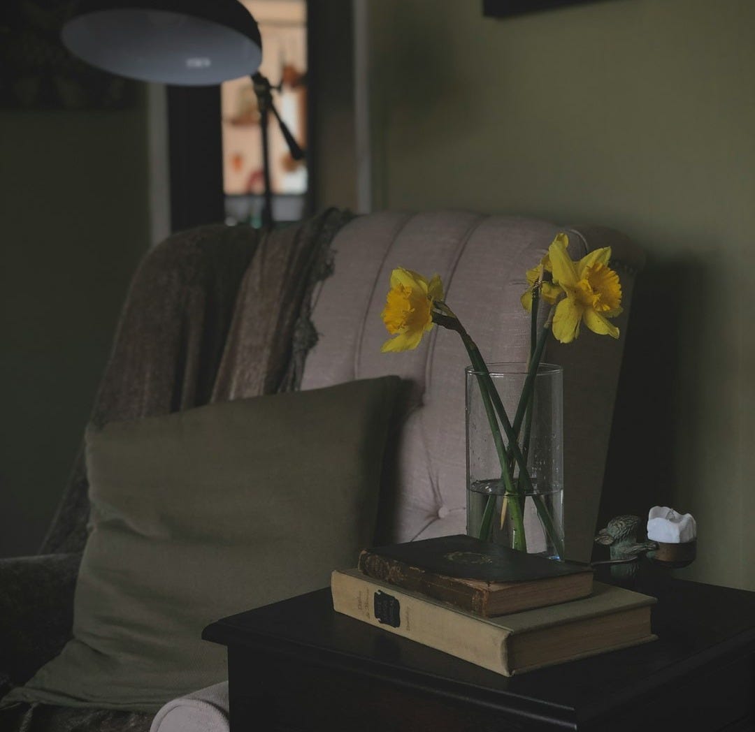 a table with a book and a vase of flowers on it a table with a book and a vase of flowers on it