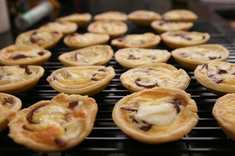 Mini pear and goat cheese tarts cooling on a wire rack Mini pear and goat cheese tarts cooling on a wire rack