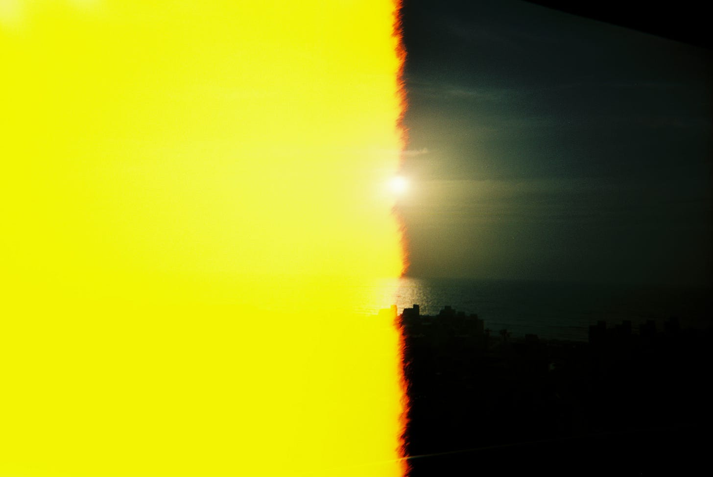 Partially overexposed film shot of sunrise over South Padre Island, left half of frame a bright yellow block