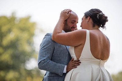 a bride and groom hugging each other after their wedding