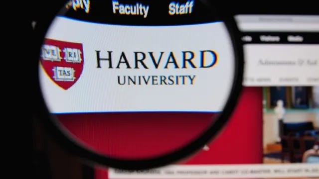 Photo of Harvard University homepage on a monitor screen through a magnifying glass Photo of Harvard University homepage on a monitor screen through a magnifying glass