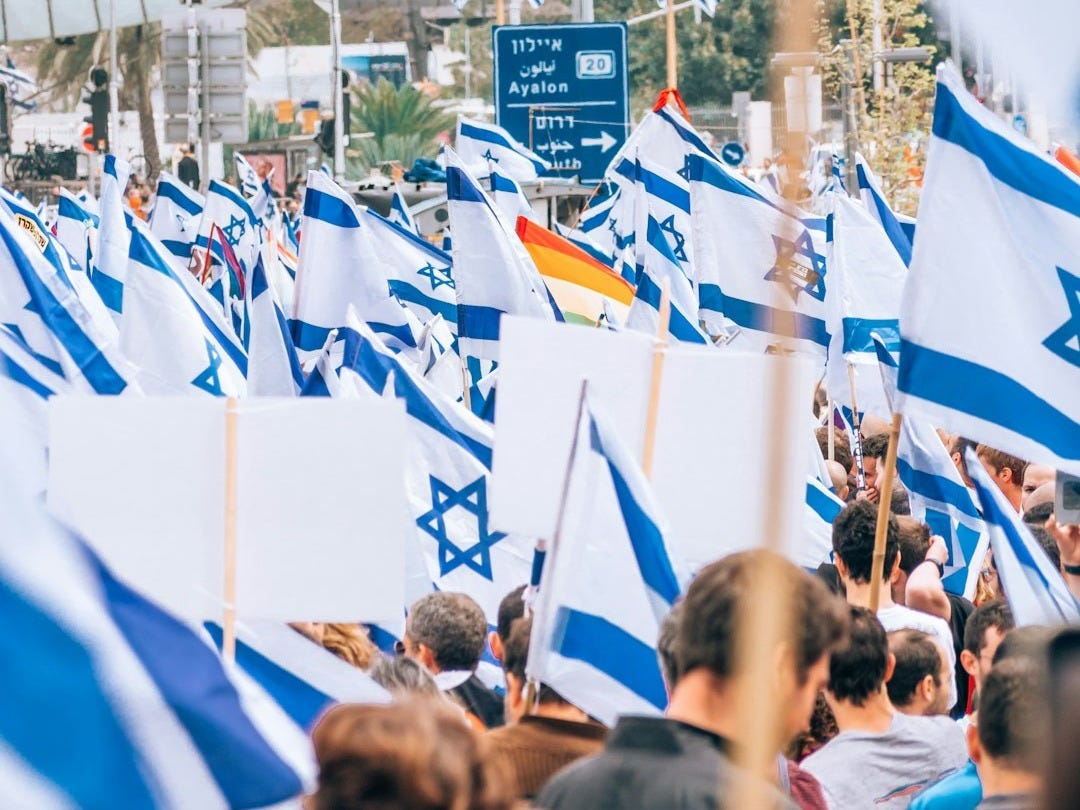 a large group of people holding flags in the street a large group of people holding flags in the street