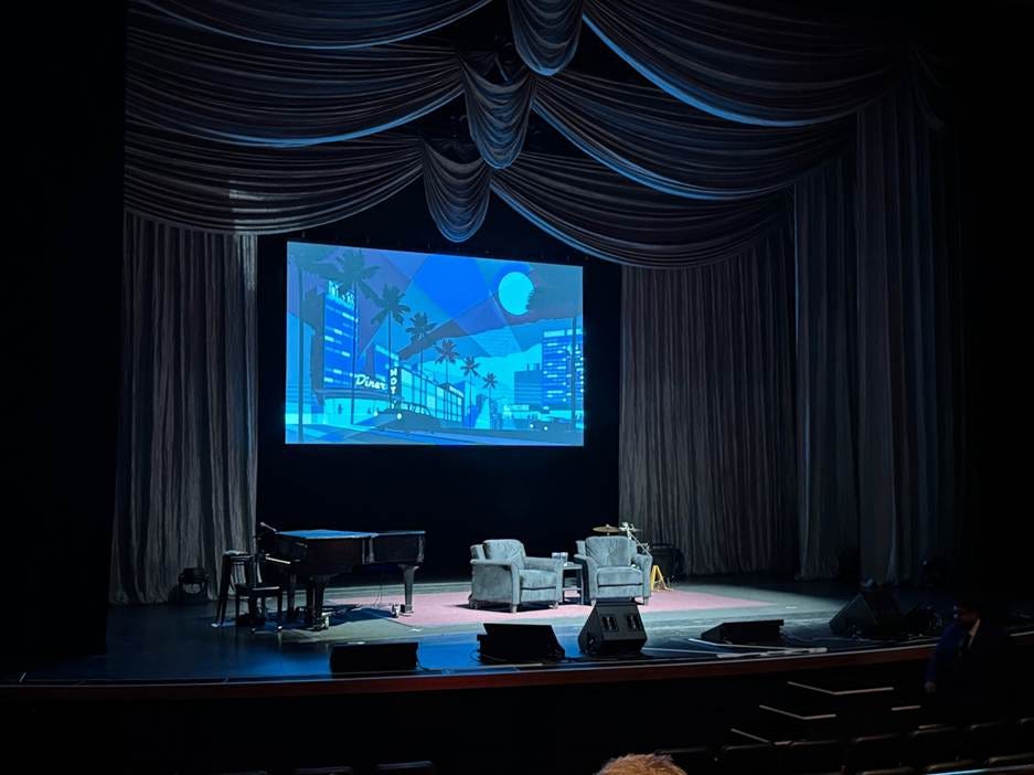 A stage with a large screen and a piano

AI-generated content may be incorrect.
