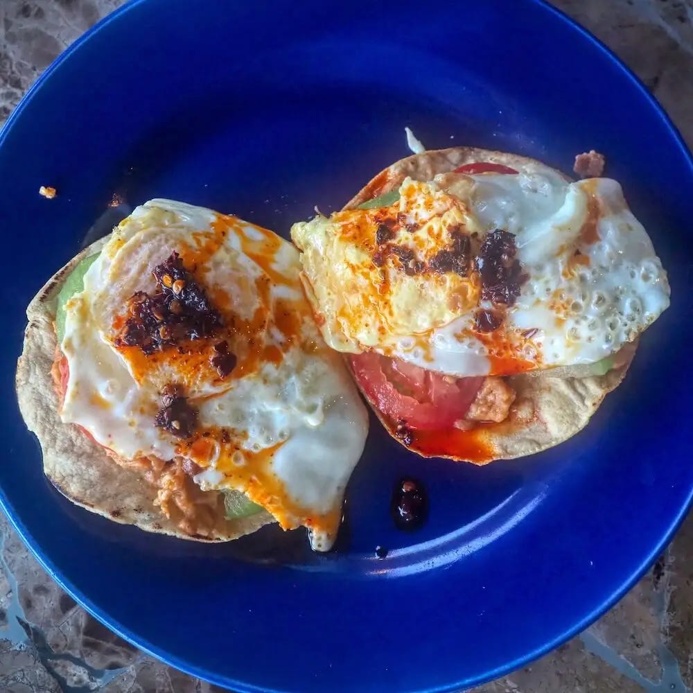 2 tostadas with a fried egg and salsa macha on top
