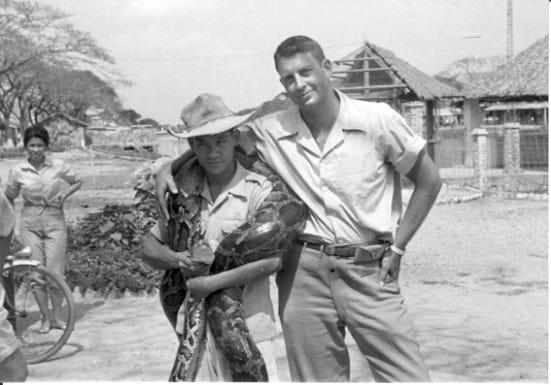 A person holding a large snake

Description automatically generated