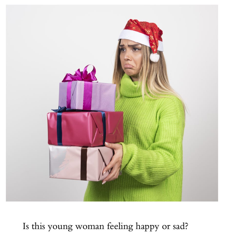 image of a young blonde woman in a green sweater and santa hat holding a stack of presents with a huge frown on her face