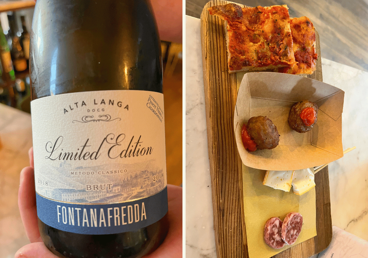 [Hand holding a bottle of Fontanafredda Alta Langa Brut next to a wooden board with meatballs, cheese, and salami [Hand holding a bottle of Fontanafredda Alta Langa Brut next to a wooden board with meatballs, cheese, and salami