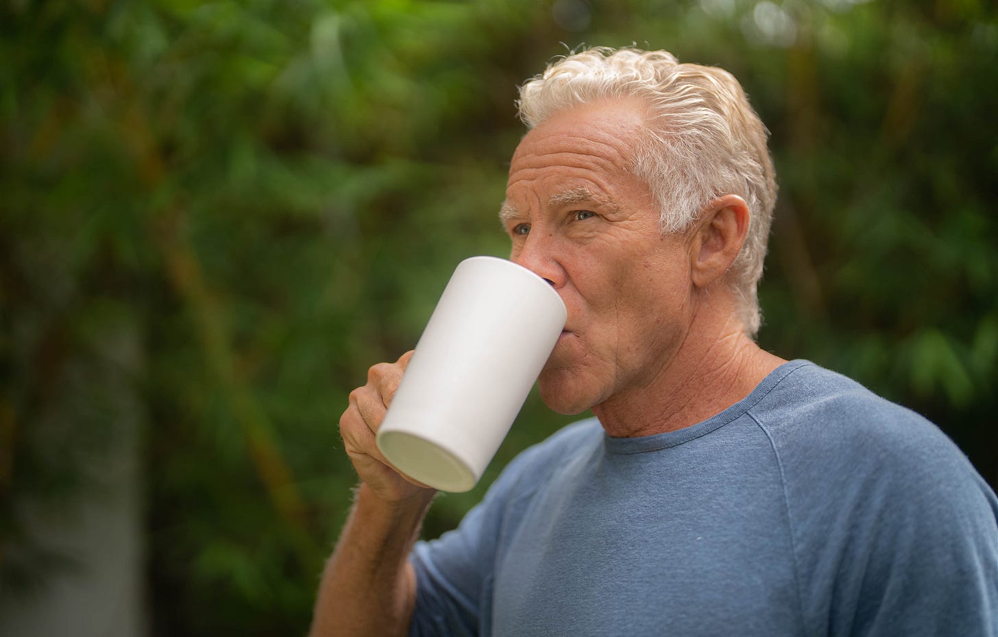 Mark sipping from a mug of coffee.