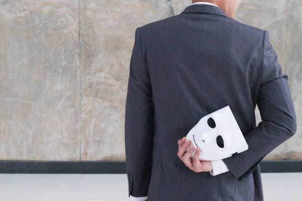 Businessman holding white mask in his hand dishonest cheating agreement.Faking and betray business partnership concept Businessman holding white mask in his hand dishonest cheating agreement.Faking and betray business partnership concept business man wearing mask stock pictures, royalty-free photos & images