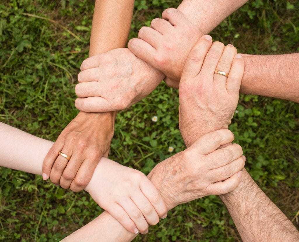 Hands gripping each other in a circle of support Hands gripping each other in a circle of support