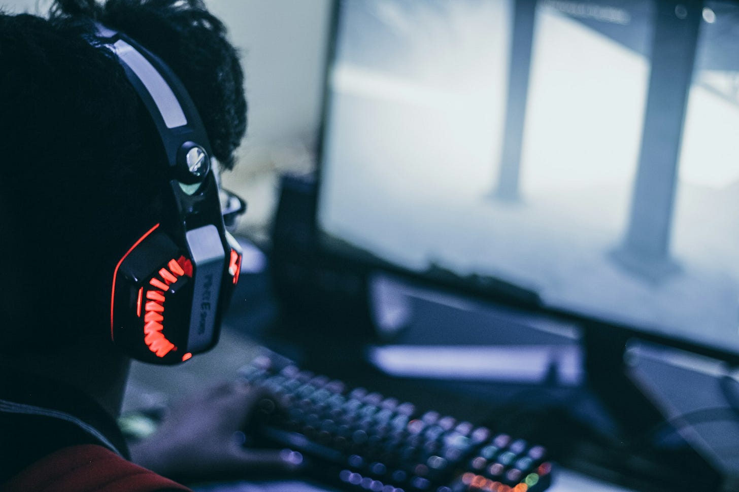 Person with headphones playing video game Person with headphones playing video game