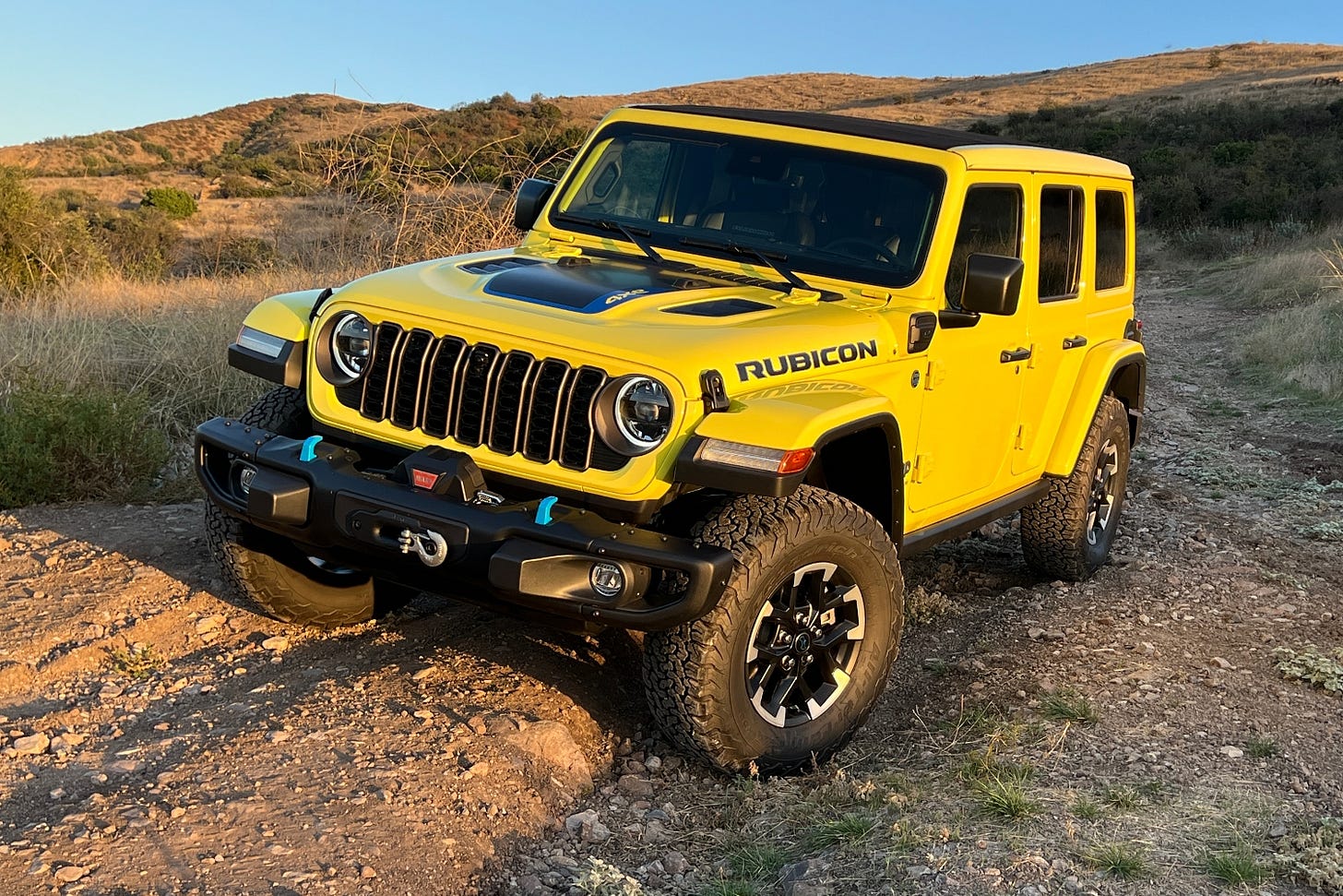 A 2024 Jeep Wrangler 4xe Rubicon in High Velocity Yellow is parked on an off-roading trail in California. A 2024 Jeep Wrangler 4xe Rubicon in High Velocity Yellow is parked on an off-roading trail in California.