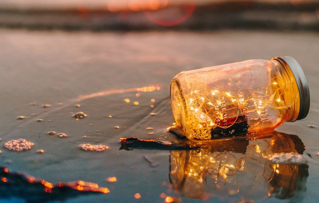 clear glass mason jar on beach during sunset clear glass mason jar on beach during sunset