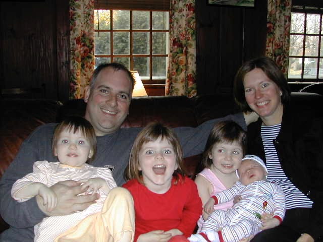 Jill and her husband sitting on the couch with her four children Jill and her husband sitting on the couch with her four children