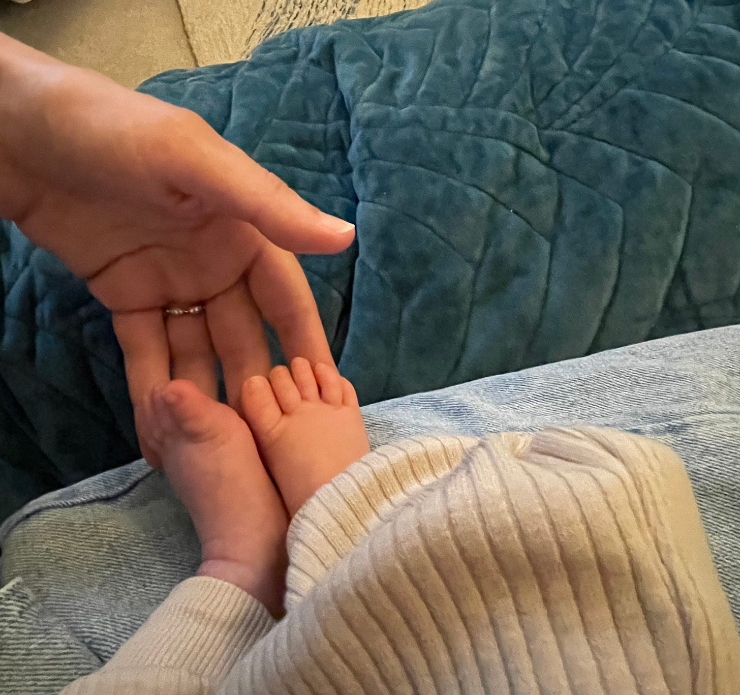 Photo image showing the author's hand holding her baby's feet