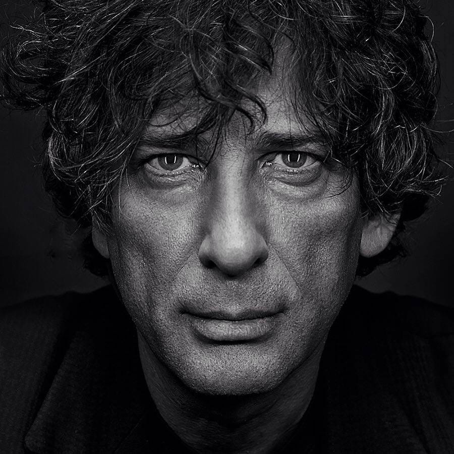 Black and White photo of Neil Gaiman. Shaggy hair and clean shaven.