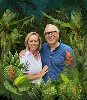 Hayley and John Rocco stand in an illustrated jungle scene