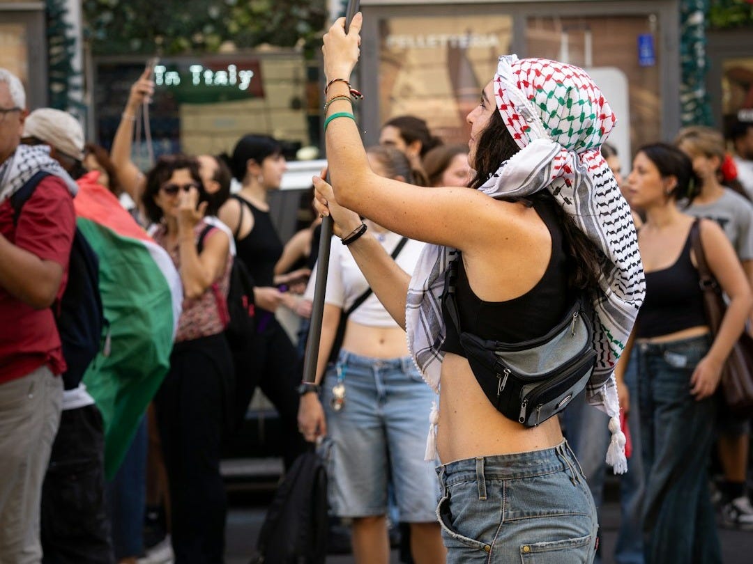 Woman waves palestinian flag at a rally