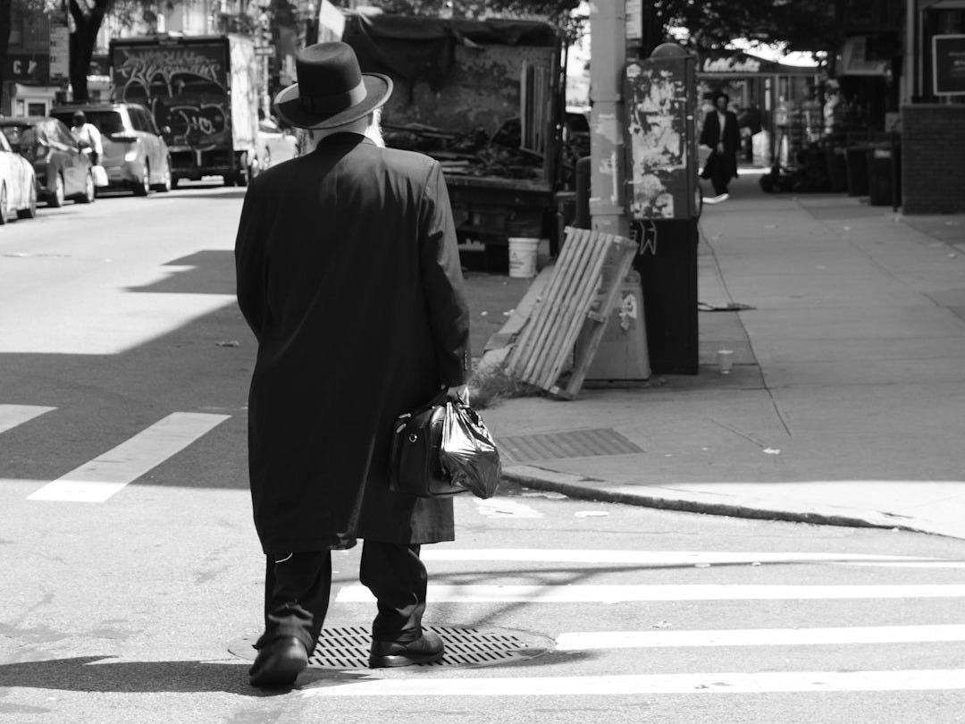 A man in a suit is walking down the street A man in a suit is walking down the street