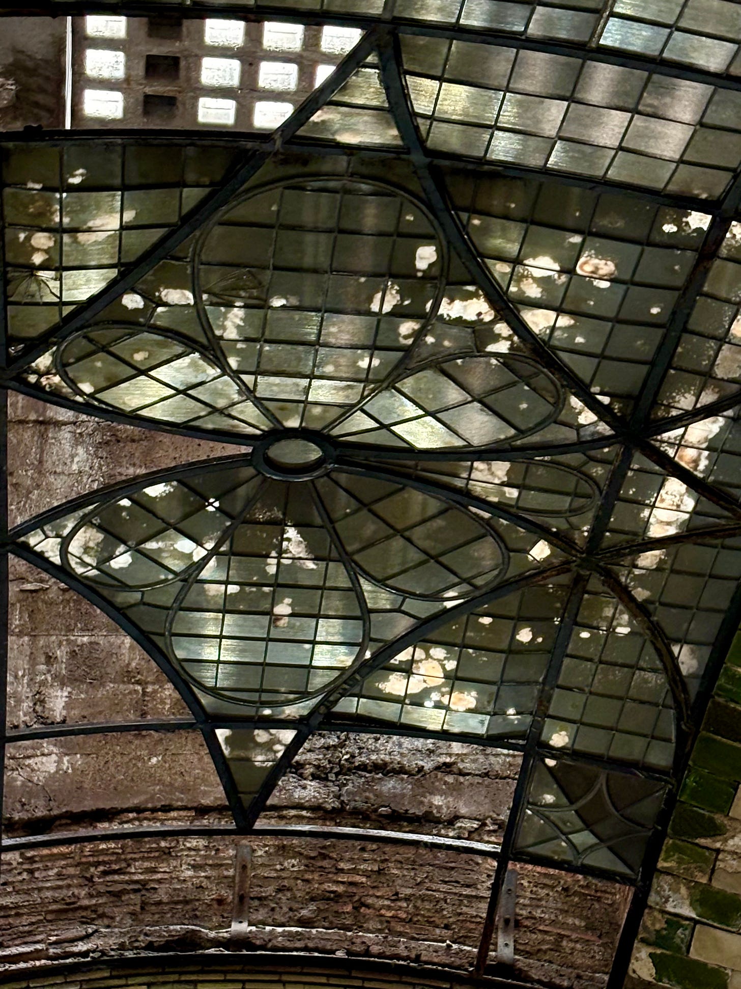 A close-up of the abstract floral pattern designed in metal and tiles of glass.