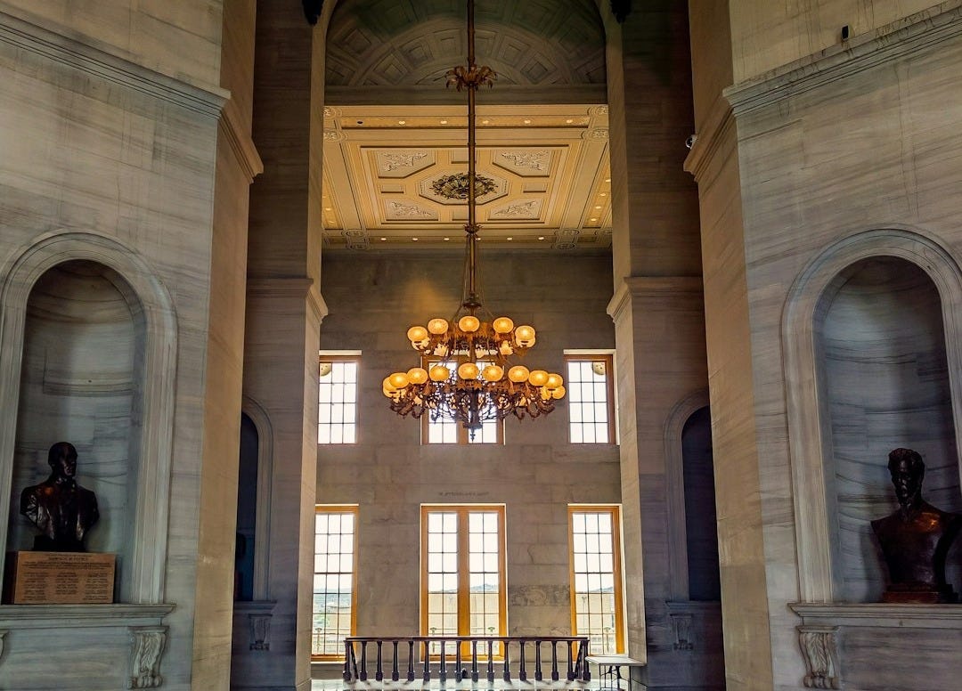 a large room with a chandelier and a large arched doorway