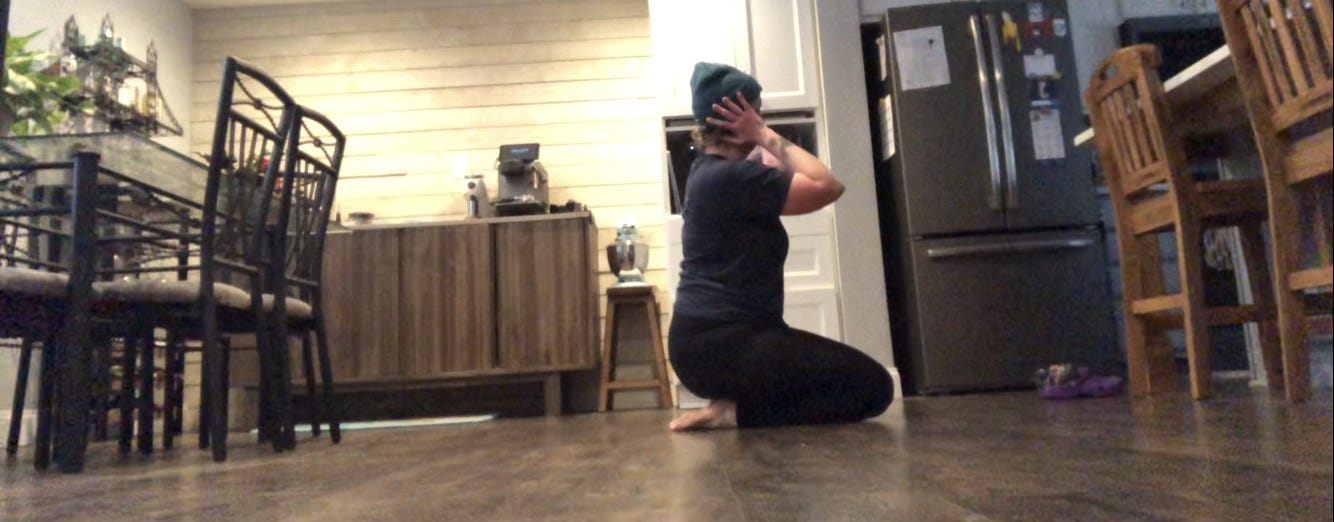 A person dances in a kitchen.