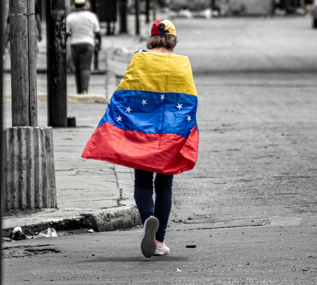 A person walking down a street holding a flag