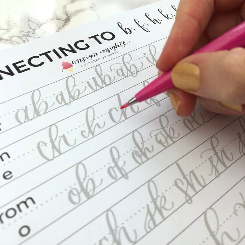 May include: A calligraphy practice sheet with the words "CONNECTING TO b, f, h, k" at the top. The sheet includes lines for practicing connecting letters in cursive handwriting. A pink pen is being used to practice writing the letters "ch ch ch" on the sheet.