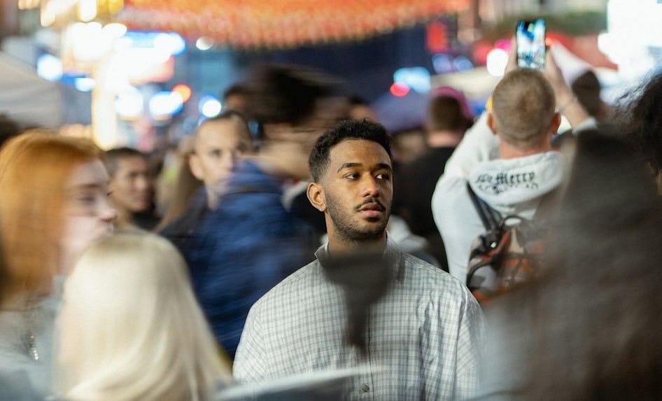 a crowd of people walking down a street at night