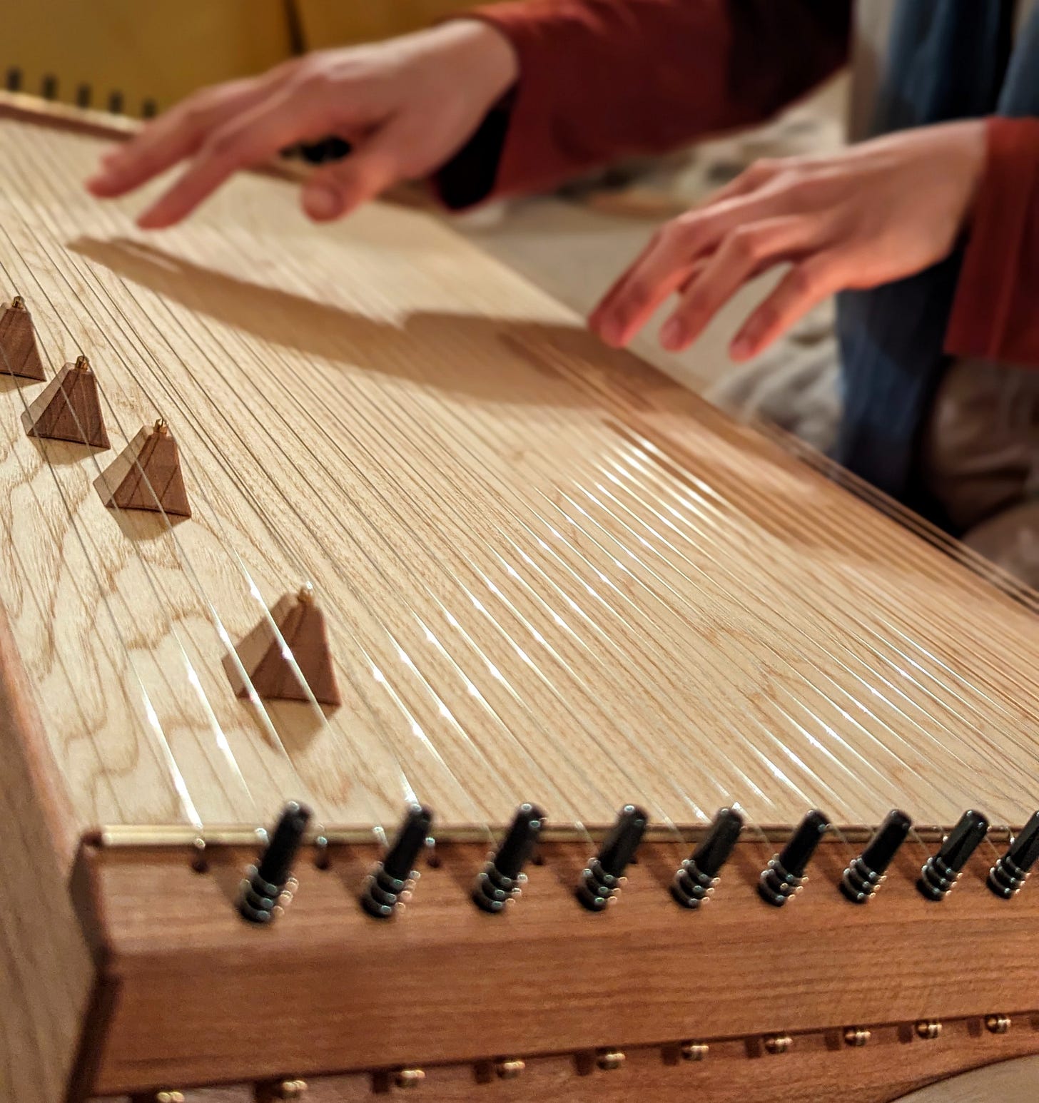 hands playing a traditional monochord instrument