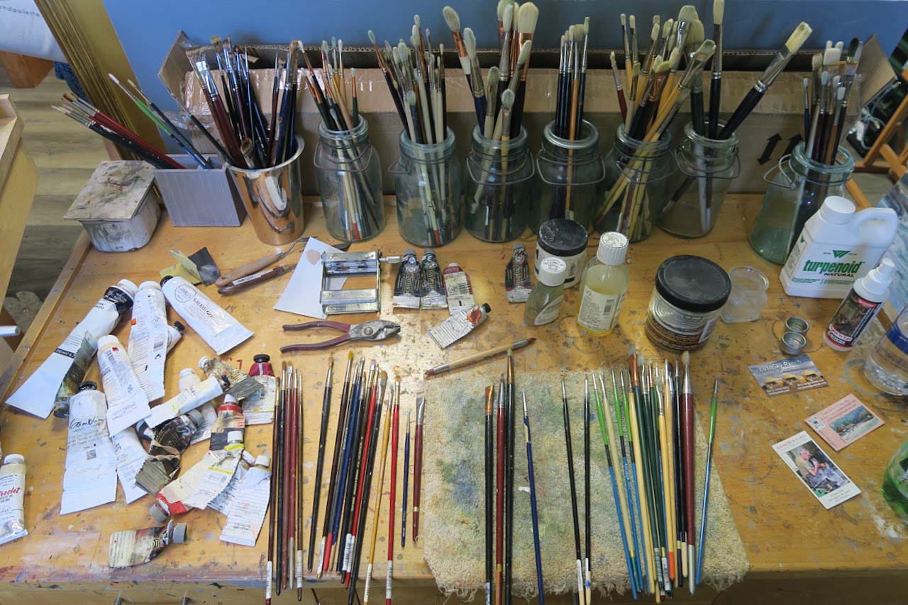 A table full of paint brushes

AI-generated content may be incorrect.