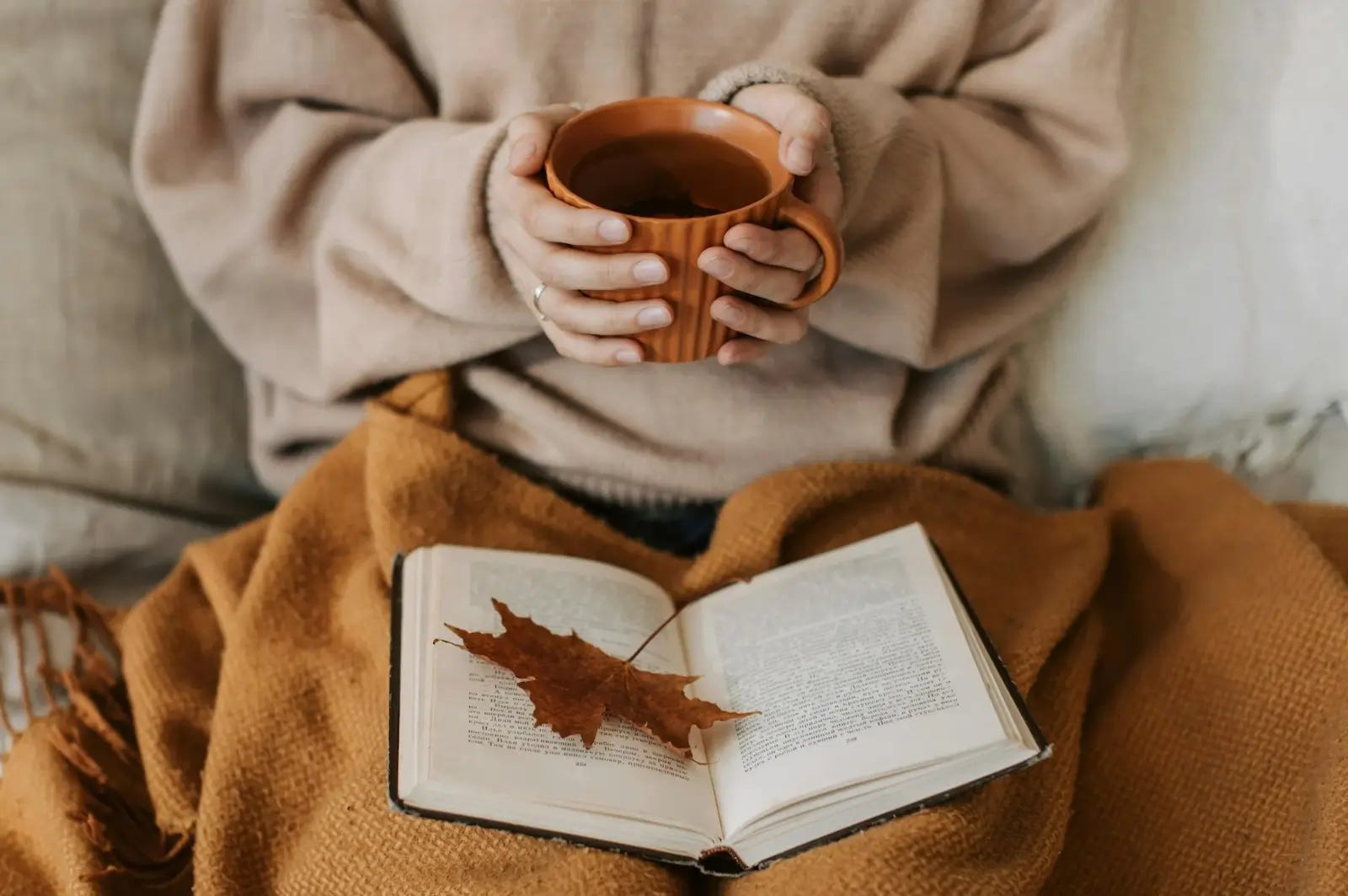 woman holding a cup of tea, reading a book and reflected on what she has learned in life woman holding a cup of tea, reading a book and reflected on what she has learned in life