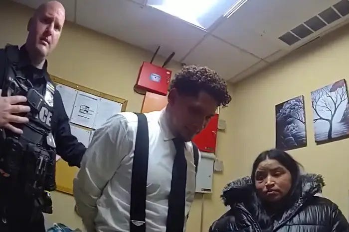 A police officer with a man in handcuffs, standing next to a woman.