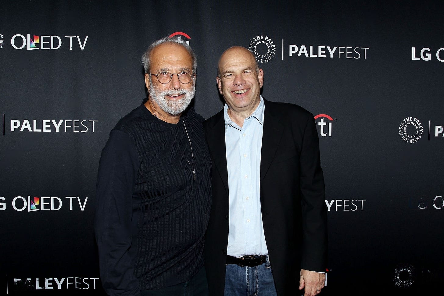 This image shows a photo of Tom Fontana (left) and David Simon (right) attending a 15 October 2017 event at New York's PaleyFest celebrating the 20th anniversary of Fontana's HBO prison drama Oz.