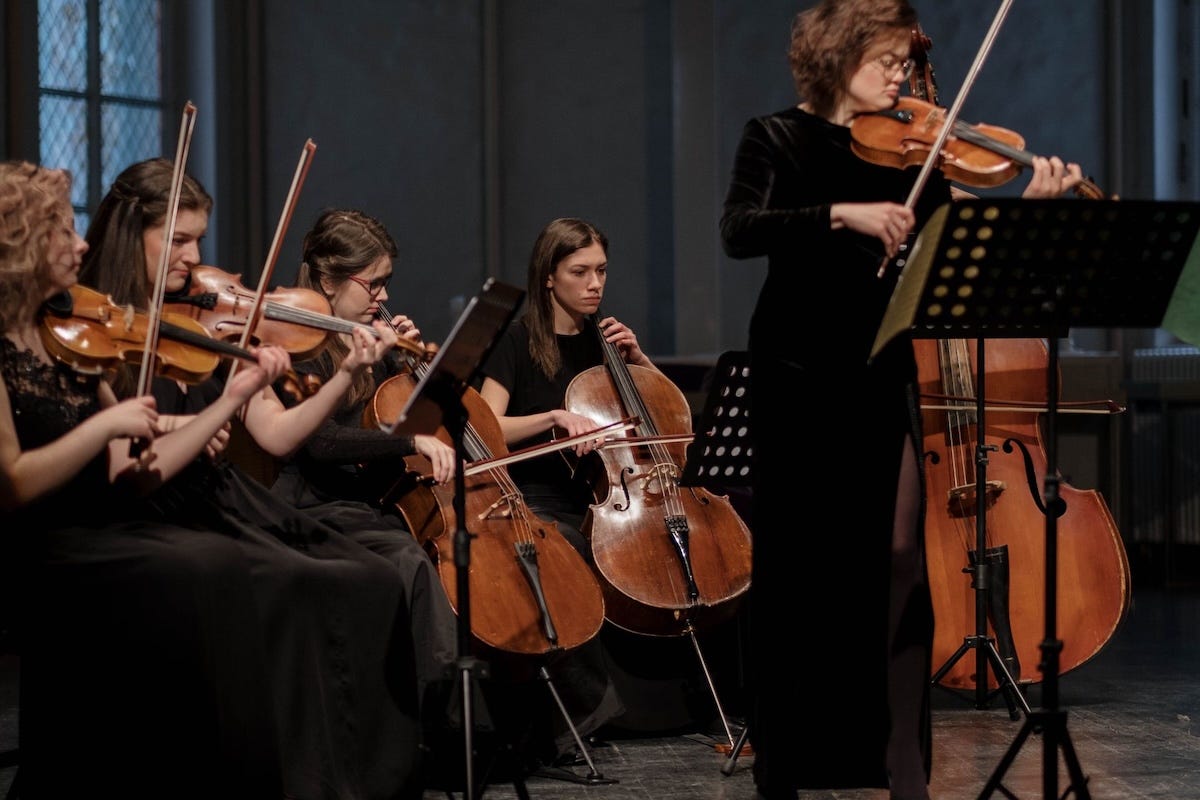 An orchestra of musicians playing in sync, symbolizing a modern, micro-specialized fractional marketing team. An orchestra of musicians playing in sync, symbolizing a modern, micro-specialized fractional marketing team.