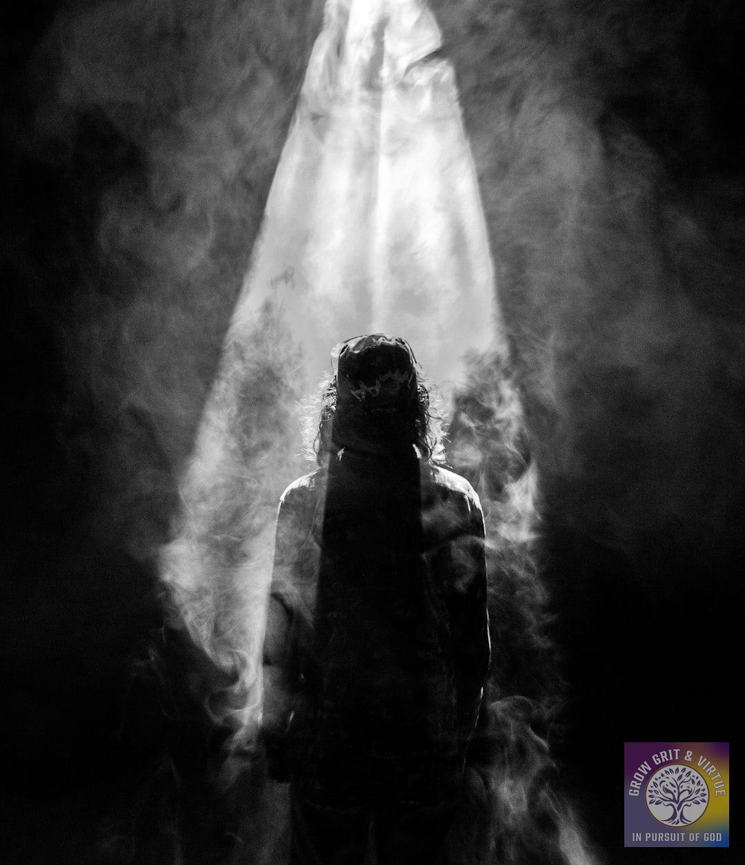 photograph of person facing opposite in smoky spotlight