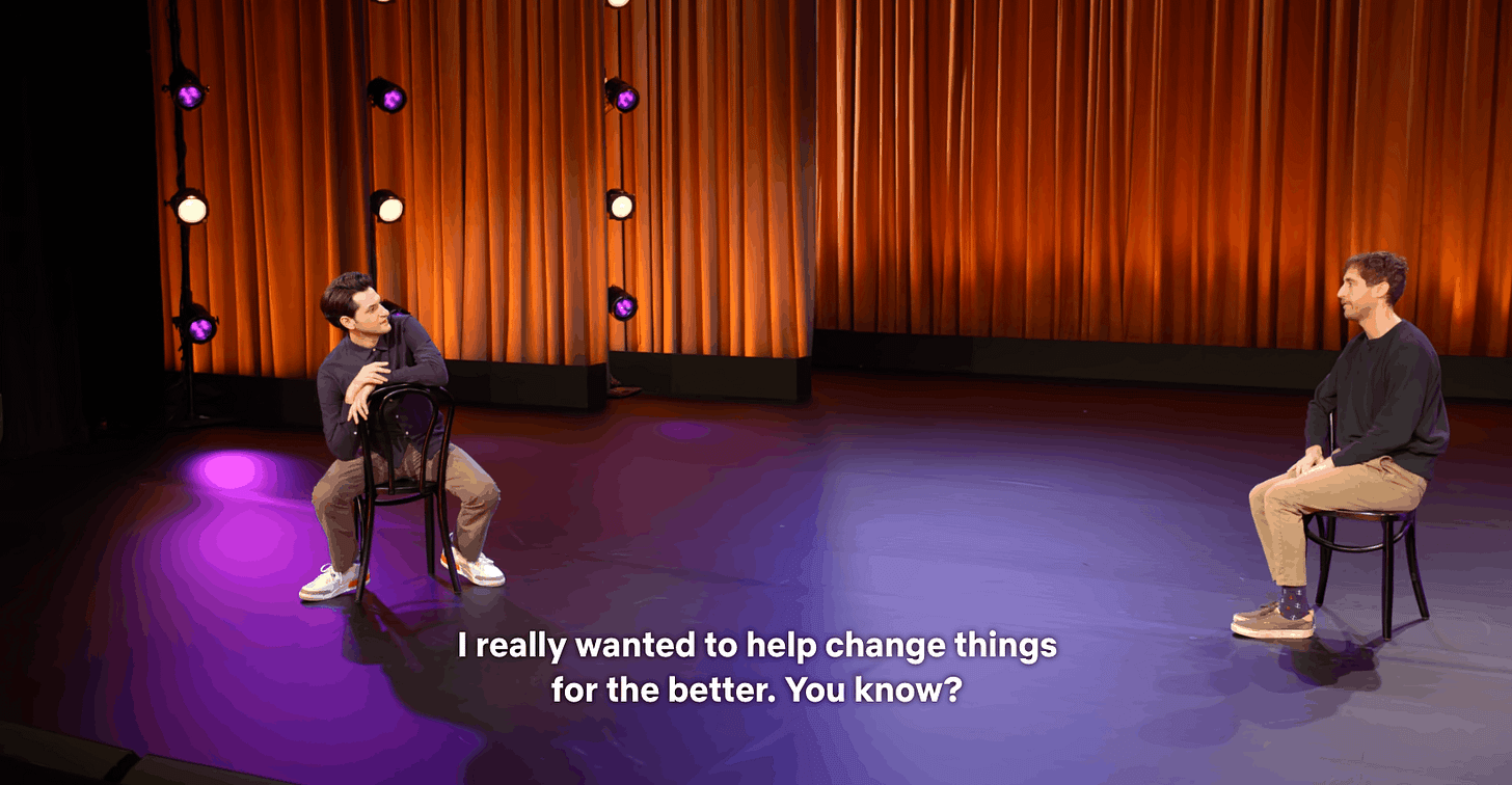 a gif of ben schwartz getting up from a chair by tucking it under his legs