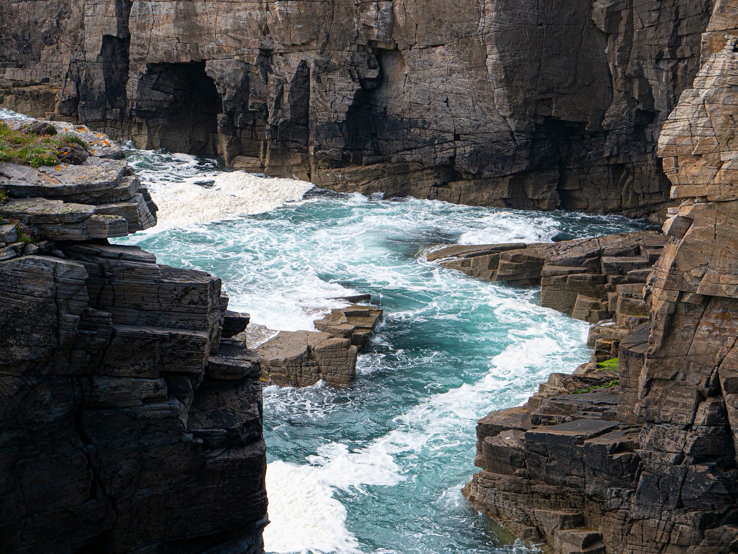 sea churning between dark cliffs