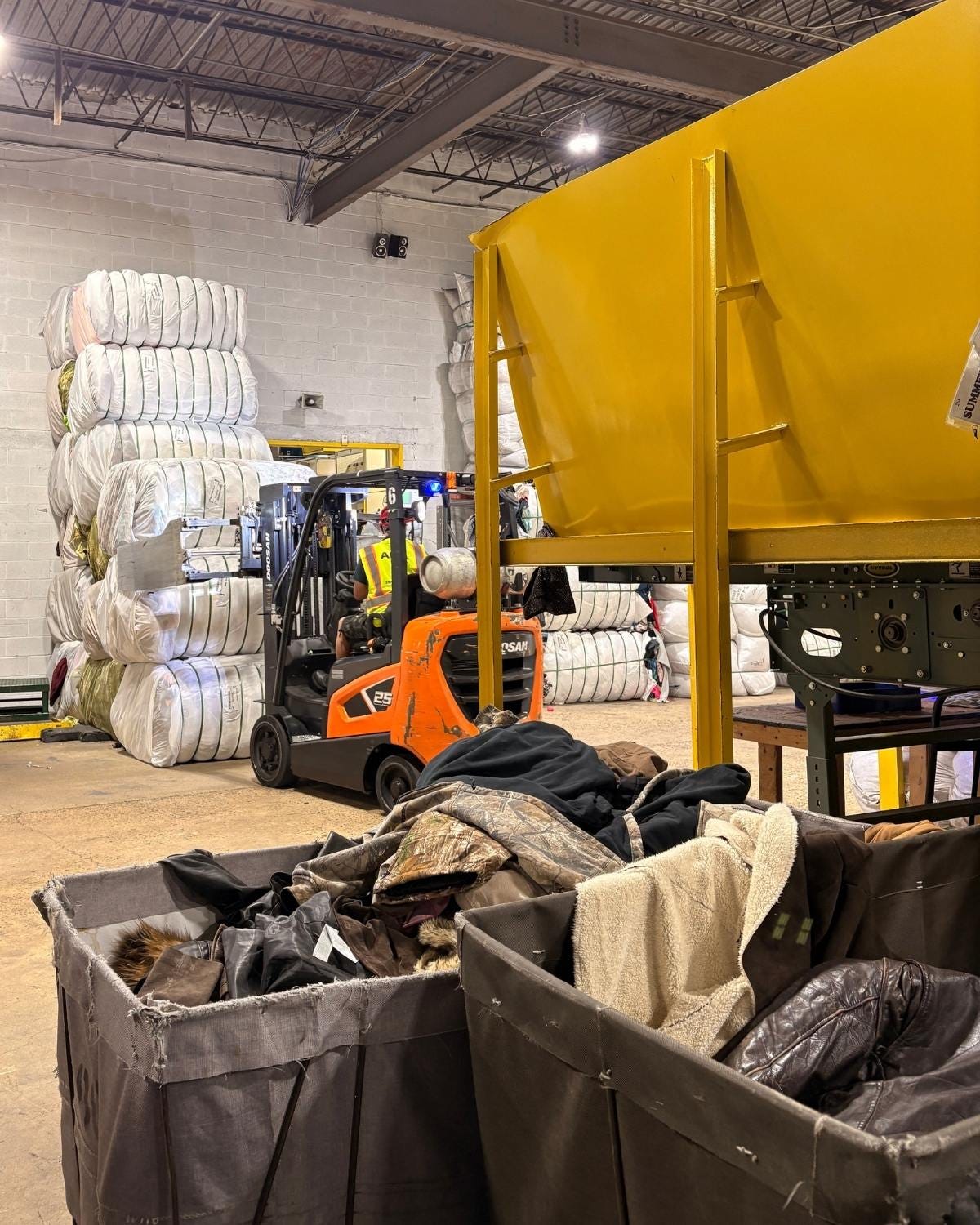 fork lift moving bales of textiles