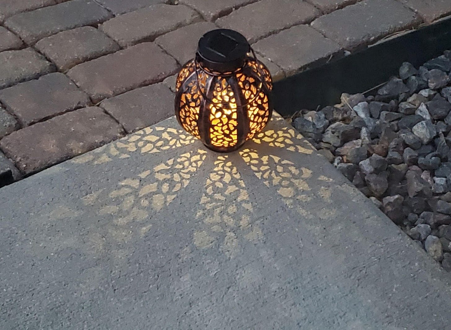 An illuminated lantern at the end of a driveway