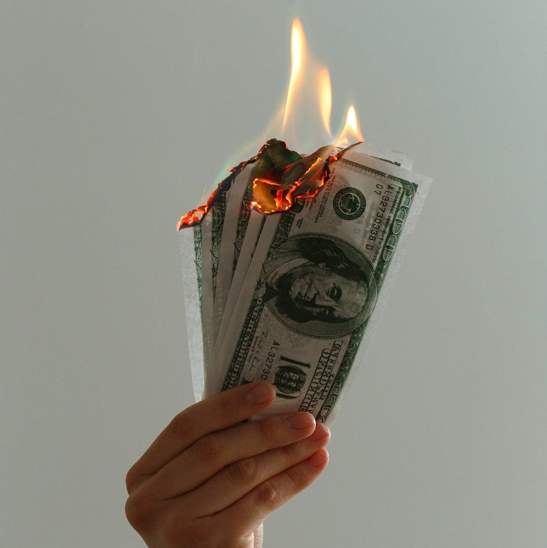 time lapse photography of several burning US dollar banknotes