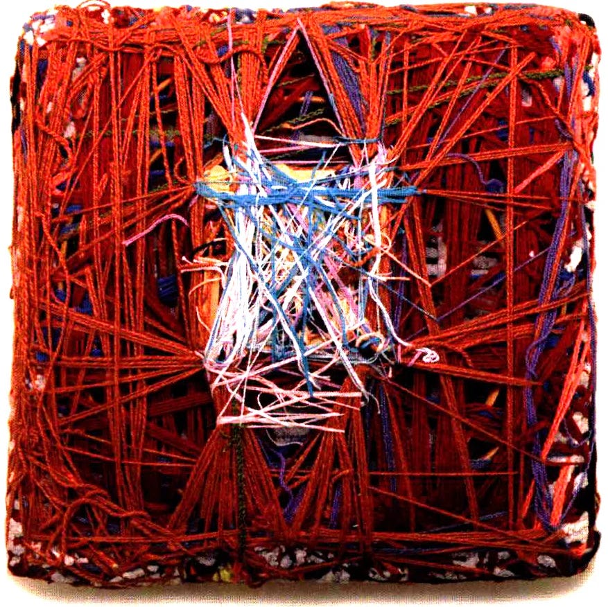 Fiber art piece made of multiple red threads entangled in a square form, with some white, blue and pink threads in the middle, forming a smaller square Fiber art piece made of multiple red threads entangled in a square form, with some white, blue and pink threads in the middle, forming a smaller square