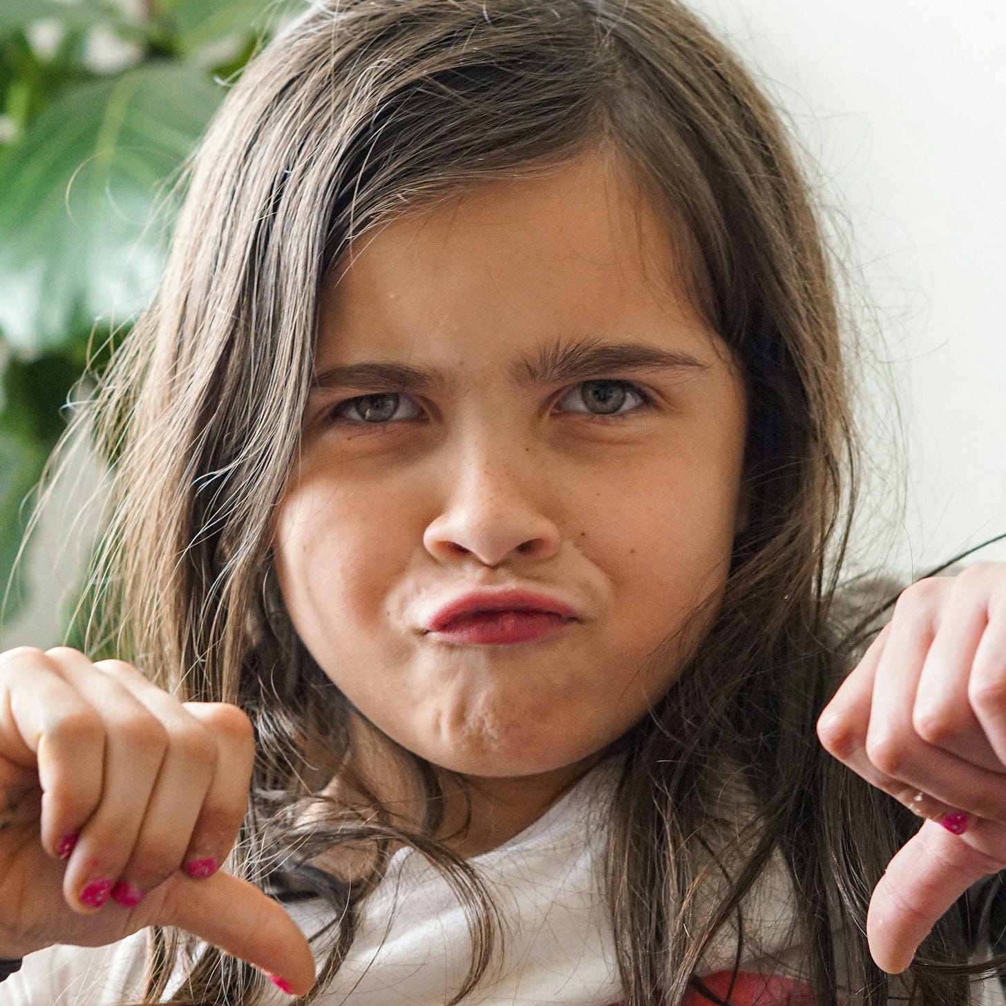 Pretty young girl making a disapproving face while giving the thumbs down about not going back to school. Pretty young girl making a disapproving face while giving the thumbs down about not going back to school.