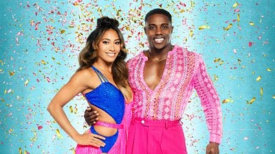 Karen wears a blue and pink cutout dress with pink fringe and Harry wears a patterned pink shirt and pink trousers