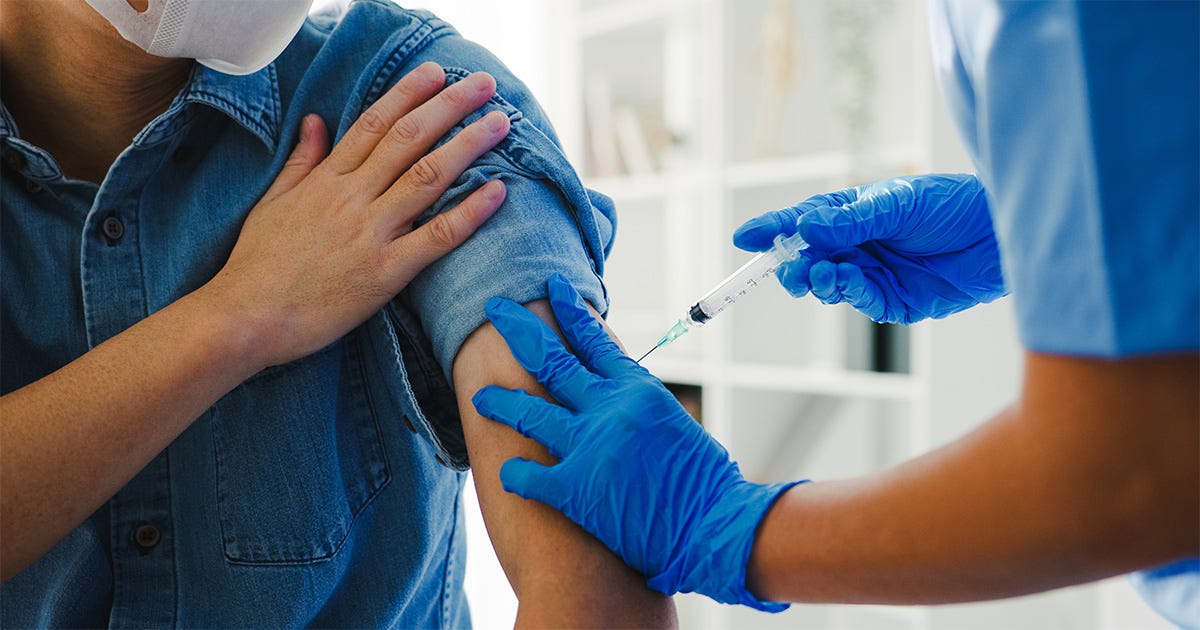 magem mostra uma pessoa, aparentemente do sexo masculino, uma vez que não se vê o rosto, tomando uma vacina aplicada por um agente de saúde cujo rosto também não é visível magem mostra uma pessoa, aparentemente do sexo masculino, uma vez que não se vê o rosto, tomando uma vacina aplicada por um agente de saúde cujo rosto também não é visível