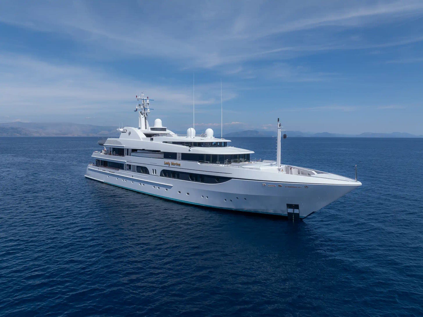 The sleek Feadship-built Lady Marina yacht cruising in calm blue waters under a clear sky.