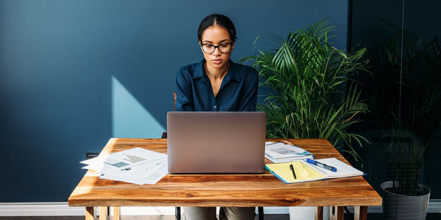 Woman working from home office looking at laptop screen